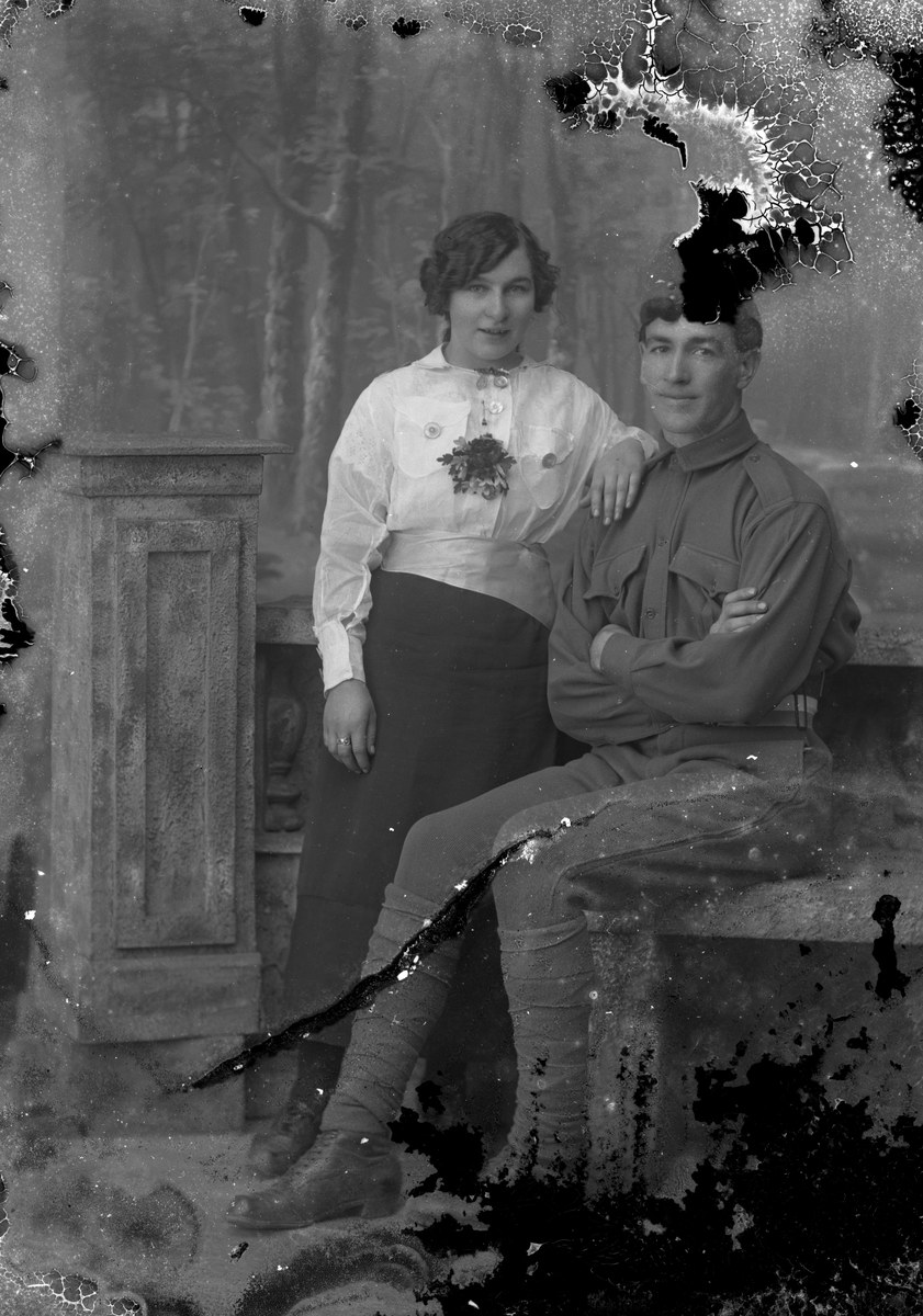 A cracked and stained old portrait of a couple before restoration